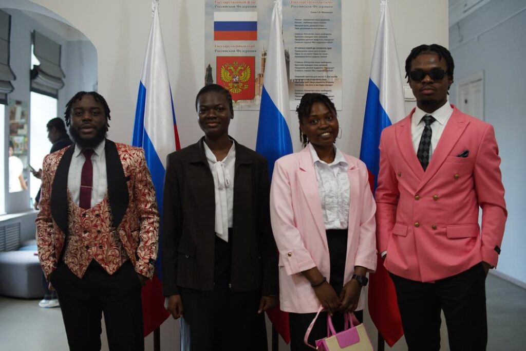 Les quatre étudiants de l’UMECI en Fédération de Russie, devant des drapeaux russes